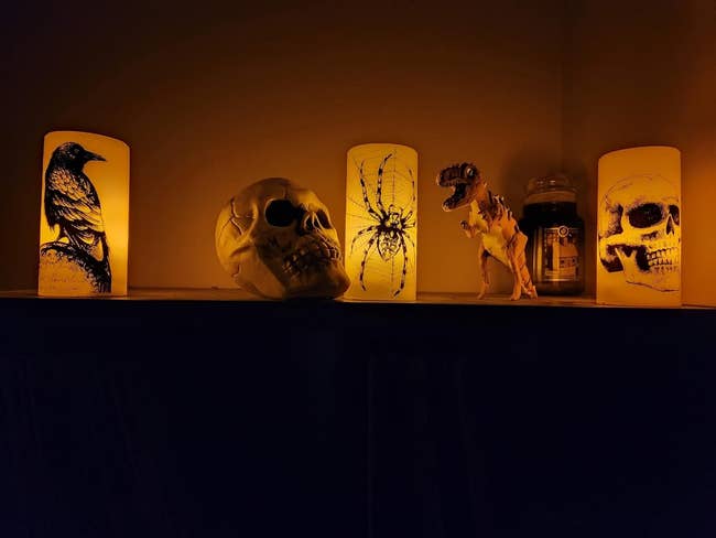 the three halloween candles with a crow, spider, and skull on each