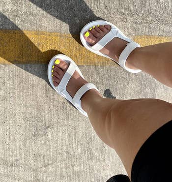 a reviewer wearing the sandals in white