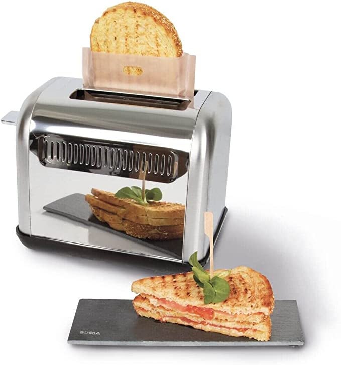 The bag with a sandwich inside being put into a toaster