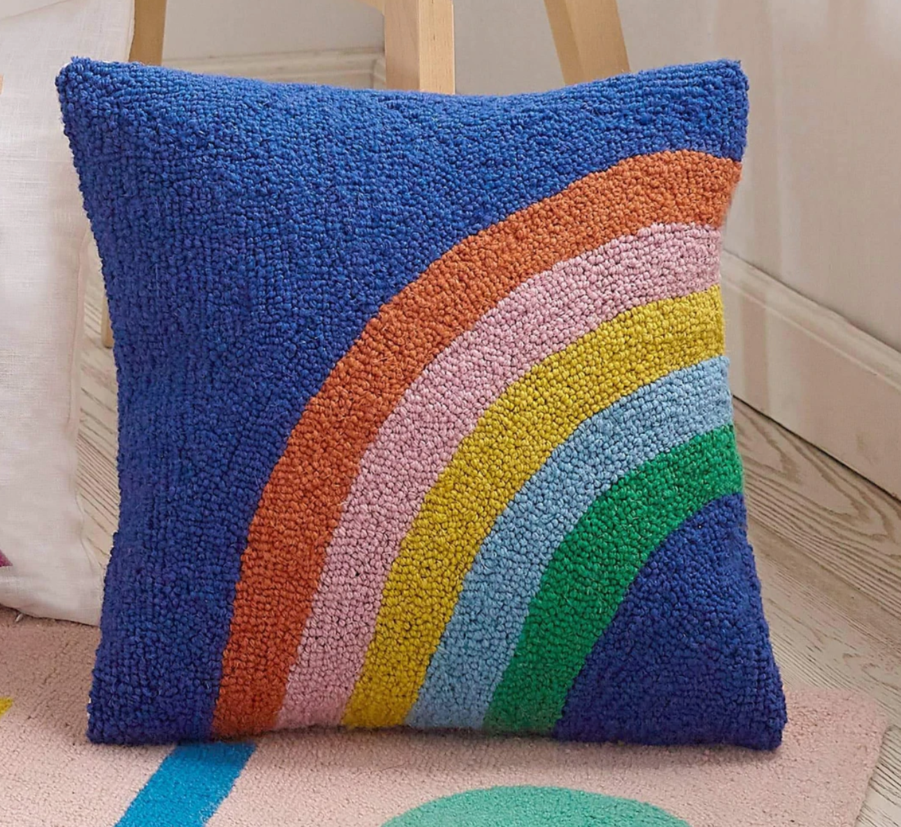 blue throw pillow with rainbow print on it