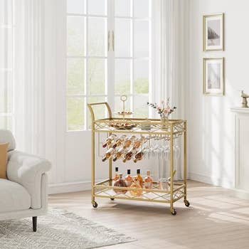 Stylish barroom cart with vino bottles, glasses, and flowers, placed successful a agleam surviving country setting