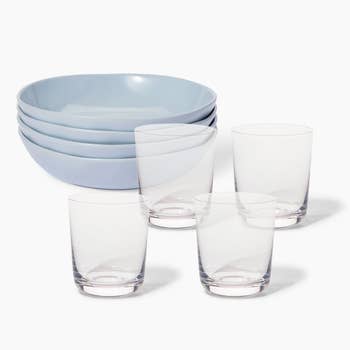 four glass cups and four blue plants