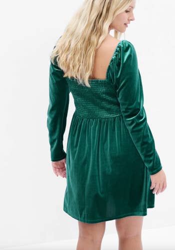 a model in a long sleeve green velvet smocked dress