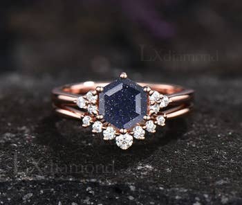 The dark blue sandstone in a hexagon cut with a rose gold band and an extra band with diamonds on it 