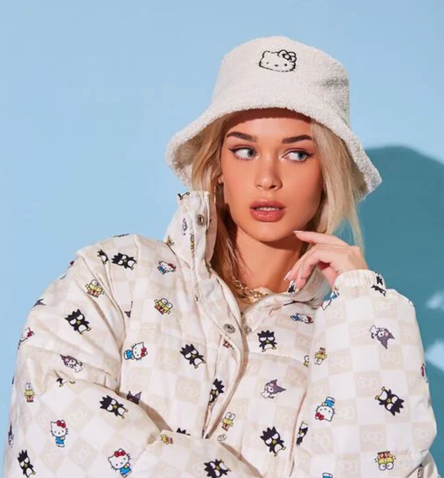 Model is wearing a cream bucket hat with an embroidered Hello Kitty on it