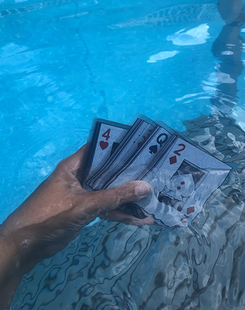 reviewer holding deck of waterproof cards in the pool
