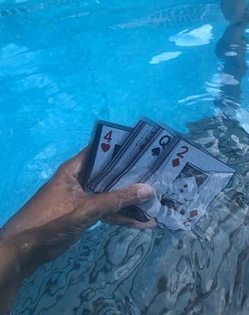reviewer holding deck of waterproof cards in the pool 