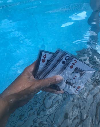 reviewer holding deck of waterproof cards in the pool 