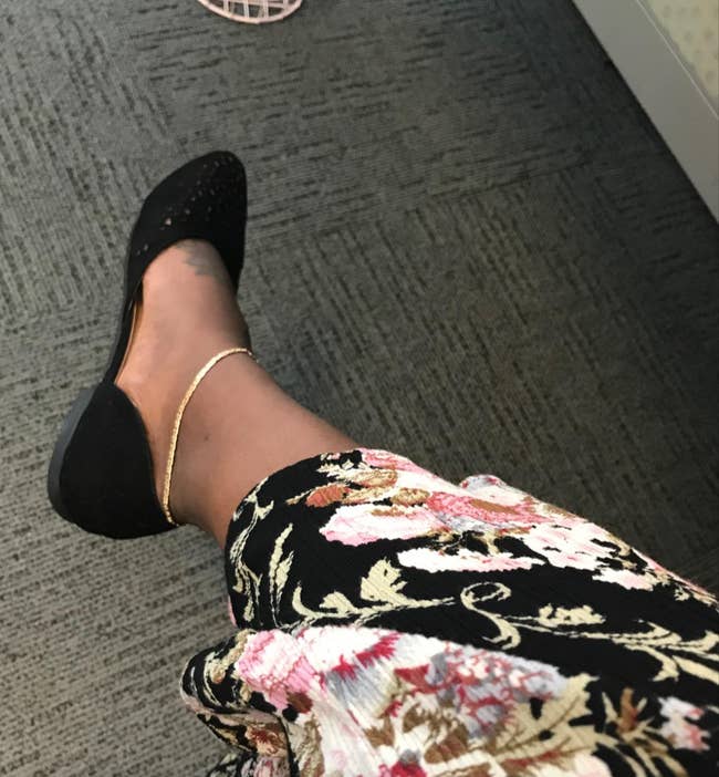 Reviewer wearing gold anklet with black flats 