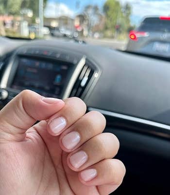 Hand with manicured nails successful  a car, focusing connected  the neat, glossy nail finish; disposable   dashboard and postulation   outside