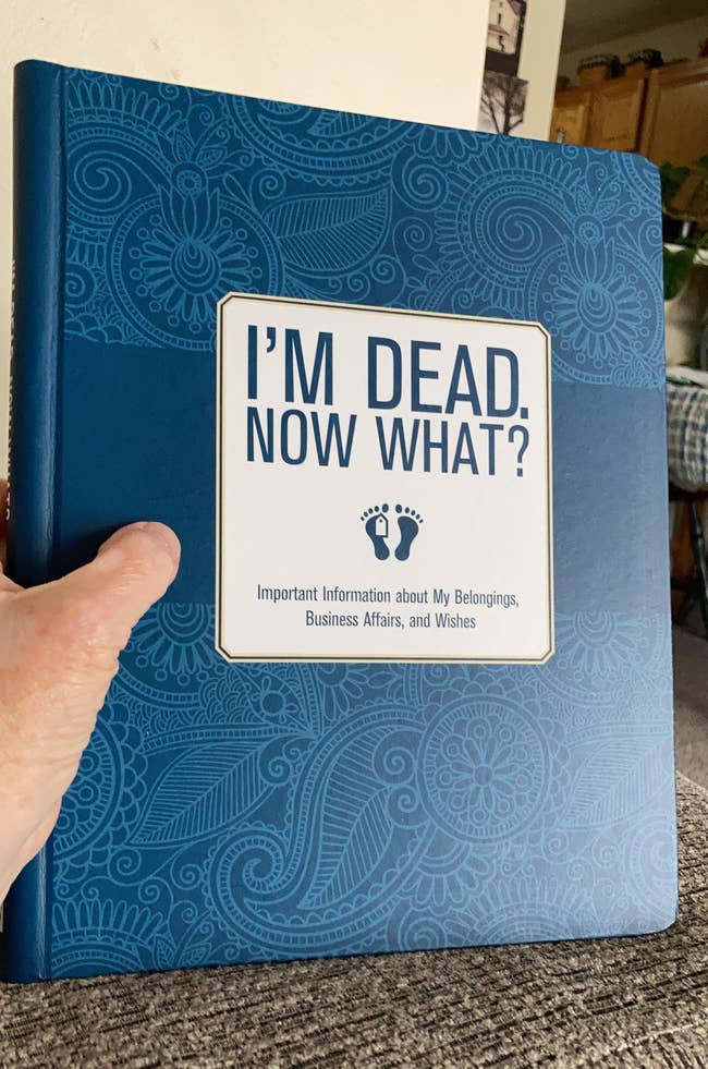 A reviewer holding  the I'm Dead, Now What? book