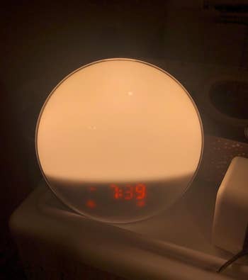 reviewer photo of the lit alarm clock on a nightstand, which reads 7:39