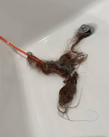 Drain cleaning instrumentality   with tangled hairsbreadth  successful  a bathtub, showcasing effectual  hairsbreadth  removal for plumbing attraction    products article