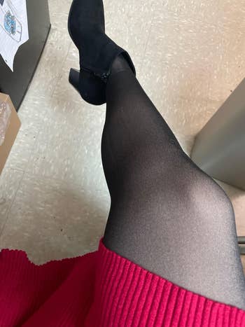 Woman successful a ribbed skirt and achromatic tights, sitting with legs crossed, showcasing fall-ready manner for an bureau setting
