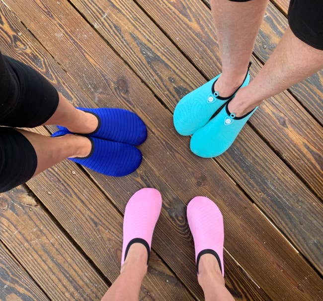 Reviewers wearing water shoes in pink, blue, and aquamarine 