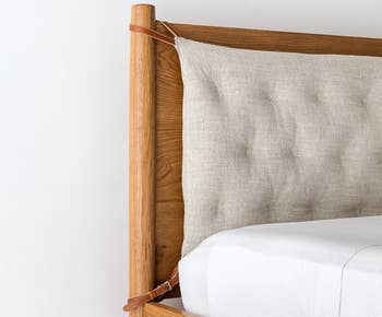 Product in white linen attached to a wooden headboard against a white mattress