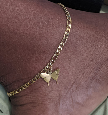 Reviewer wearing the gold butterfly anklet with the initial 