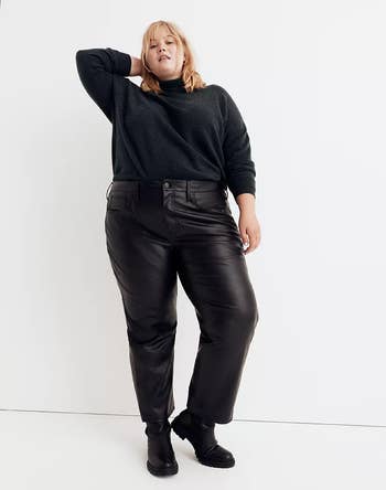 front of a model wearing black faux leather pants with a black sweater