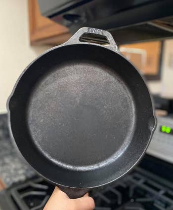 reviewer holding up the black cast iron pan