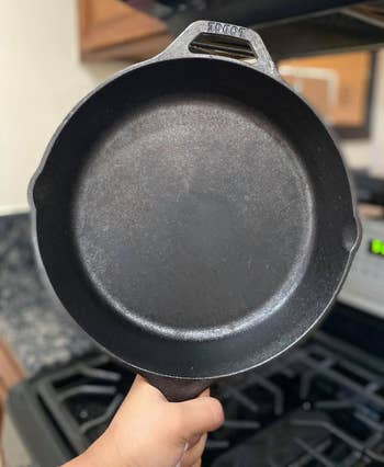 reviewer holding up the black cast iron pan