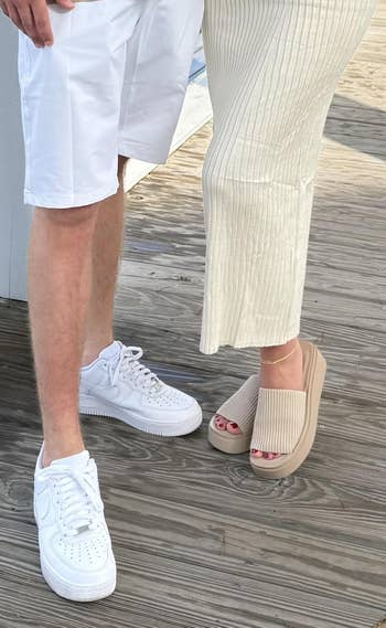 Man wearing casual sneakers and shorts stands adjacent  to pistillate   successful  ribbed knit skirt and level    sandals, showcasing summertime  footwear styles