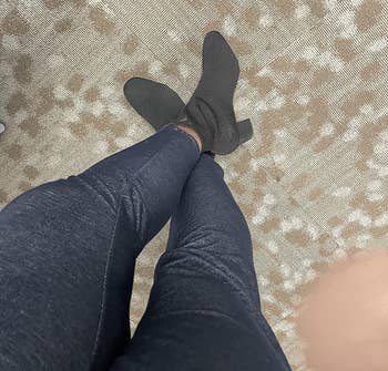 A reviewer wearing the knit booties in black