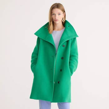 A model wearing the coat in ocean green