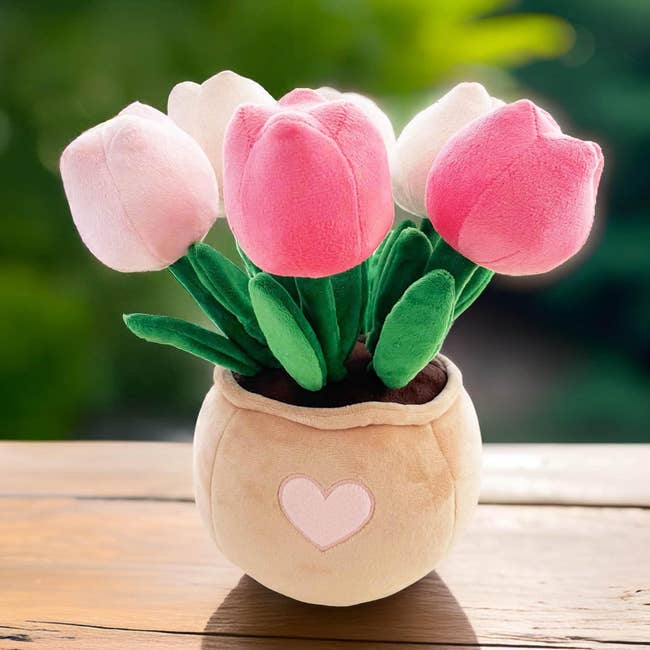 A plush bouquet of tulip-shaped toys successful a heart-decorated vase, suitable for decoration oregon gifting