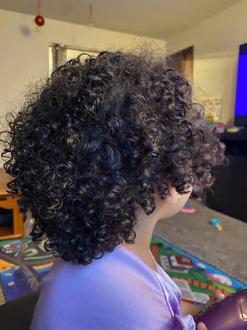 image of reviewer's child with healthy-looking curly hair