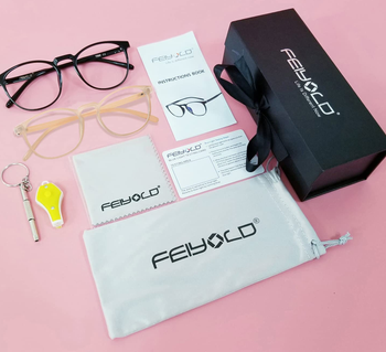 a pair of blue light-blocking glasses with all of their included accessories on a pink background