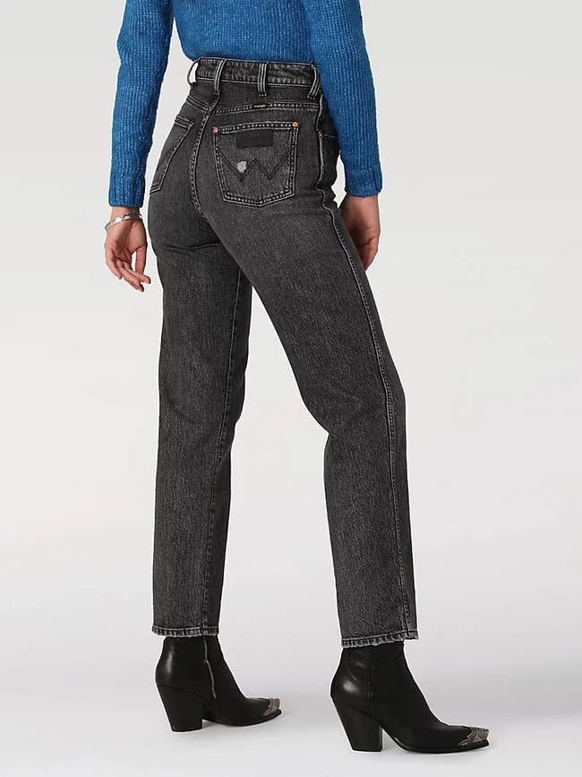 model wearing black wash denim jeans