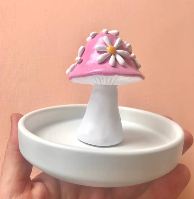 The white trinket dish with a small pink and white mushroom on the center