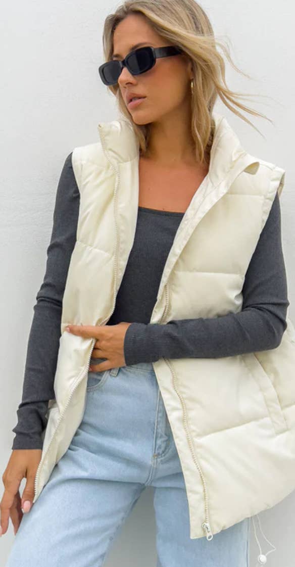 A model wearing a cream-colored puffer vest