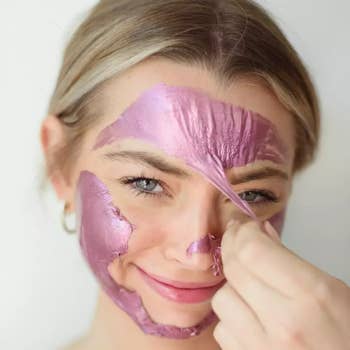 model peeling off the purple mask