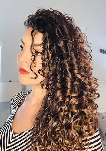 reviewer with curly hair that looks soft, moisturized, and defined after using the treatment