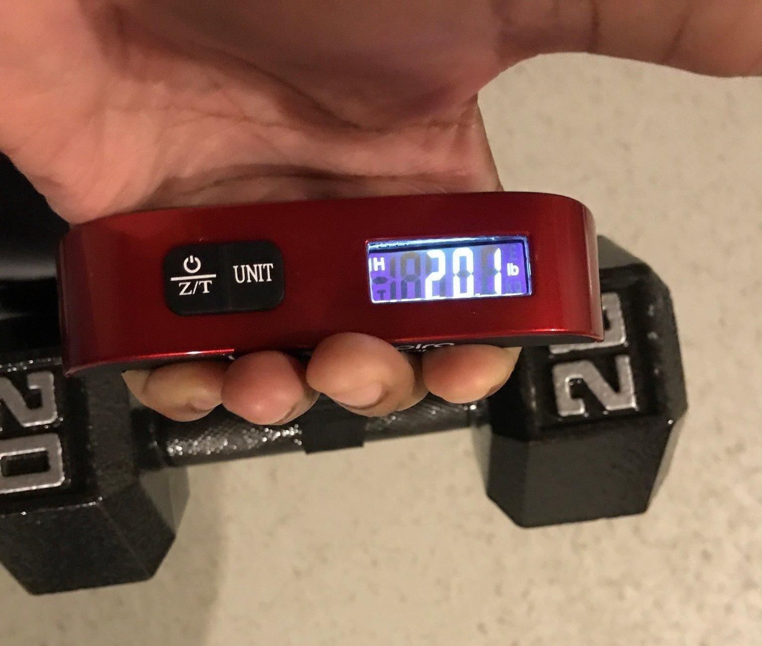 Reviewer photo of them holding the scale and 20 pound dumbbell to show it's accurate