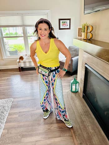 reviewer wearing the pants in diamond flower print with a yellow top