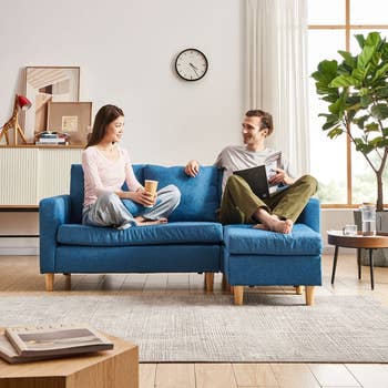 couple sitting on blue linen sectional couch