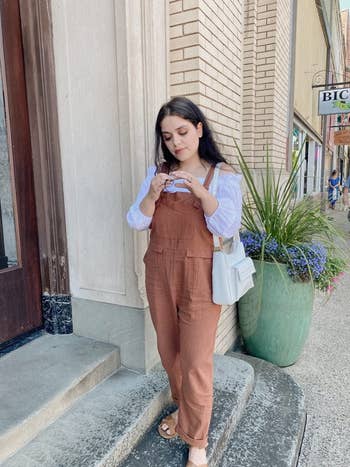 reviewer wearing the brown overalls outdoors