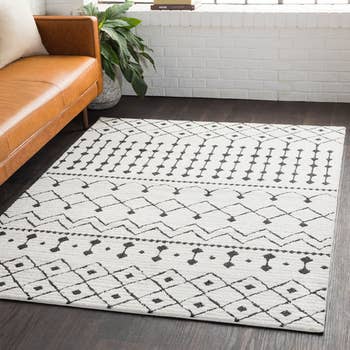 the white and black area rug in a living room, next to a couch