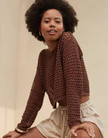Model in brown version of sweater 