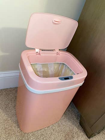 The pink trash can opened