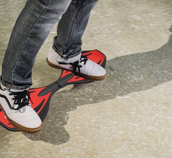 Model's sneakers standing on red and black board