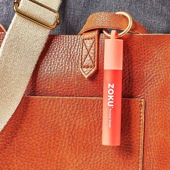 pink straw case on a purse strap