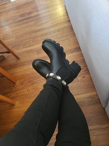 a reviewer wearing black steve madden ankle boots with jewels around the ankle