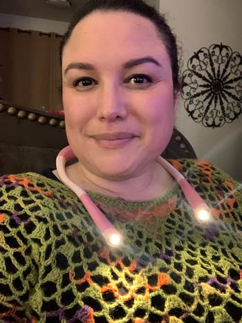 reviewer wearing a lit-up book light around her neck