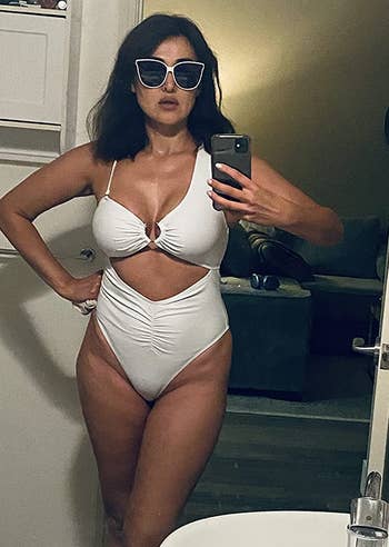 reviewer takes a mirror selfie in the white swimsuit