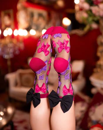model in sheer crew socks with pink and purple bows and a black bow on each calf