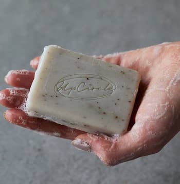 a model holding the bar soap