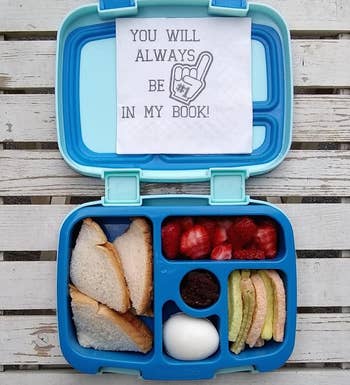 reviewer photo of the blue lunch box filled with snacks and a sweet note